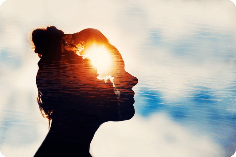 Silhouette of a woman’s profile against sky and sunlight