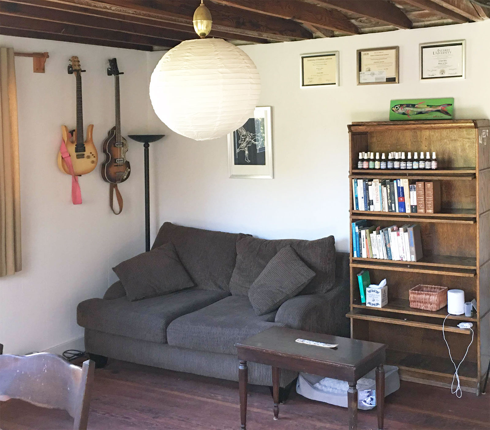 The therapy room: a sofa, guitars on the wall and a bookcase